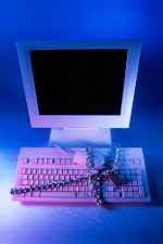 Image of a computer keyboard and mouse locked in chains and a padlock. Image provided by FreeImages.com.